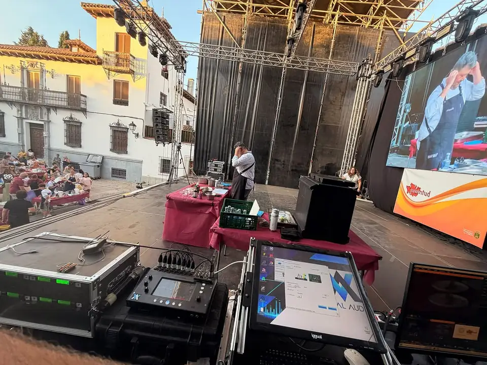 Mesa de sonido digital y monitor con el logo de Visual Audio en el control de un escenario al aire libre