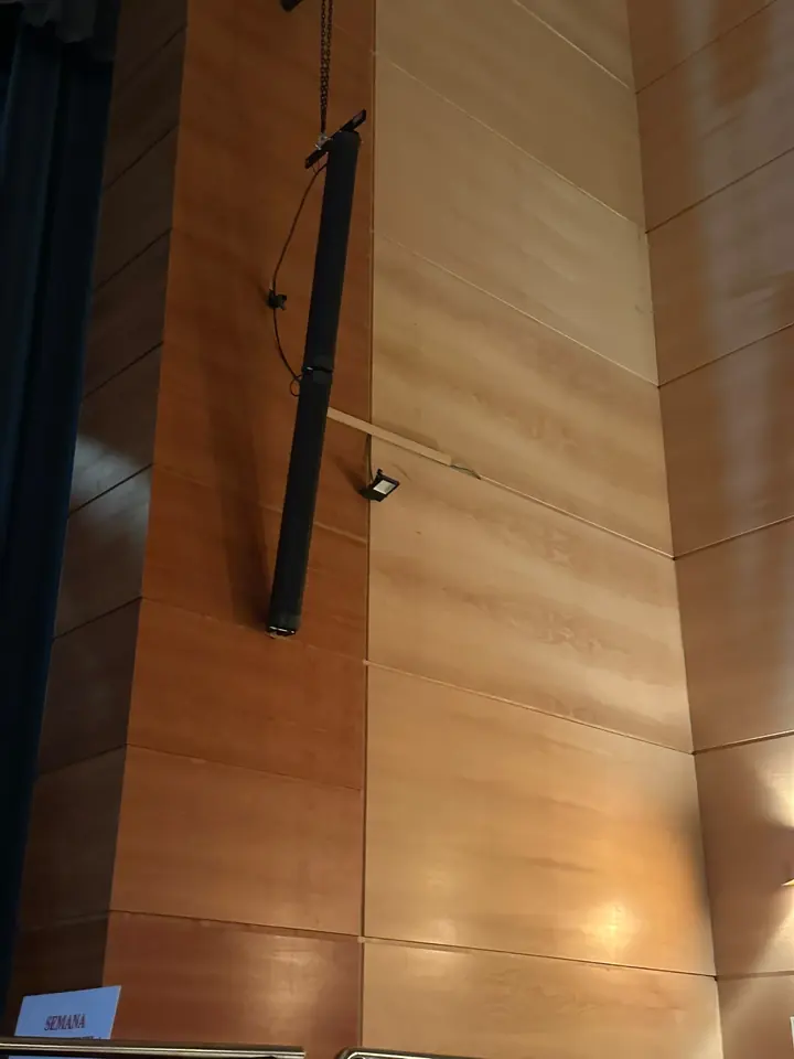 Columna Axiom AX12C instalada en la pared de madera junto al escenario